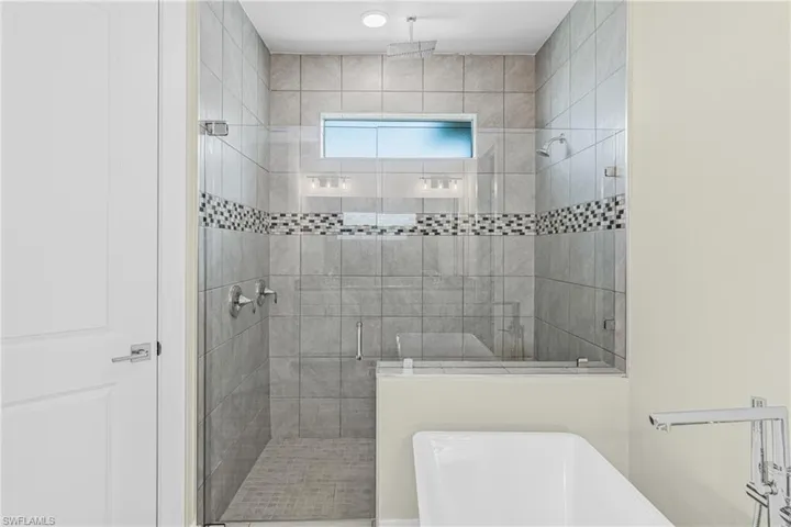 Bathroom with a shower stall and a freestanding bath