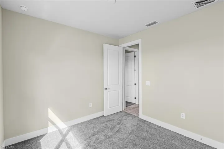 Spare room with baseboards and carpet