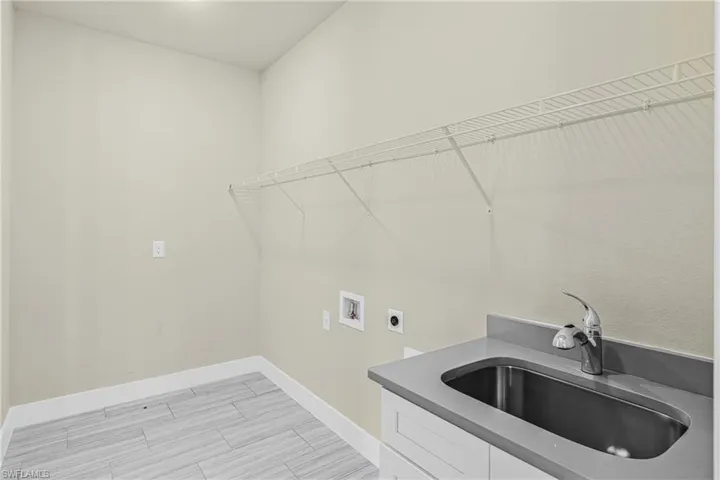 Laundry area featuring washer hookup, hookup for an electric dryer, wood finish floors, and cabinet space