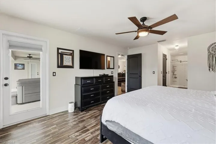 Interior space featuring wood-finish flooring, a contemporary ceiling fan with integrated lighting, and a white door with direct exterior access