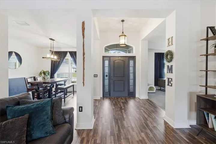 Entryway featuring a dark wood-finish door with frosted glass panels, an arched transom window, and a hanging lantern light fixture