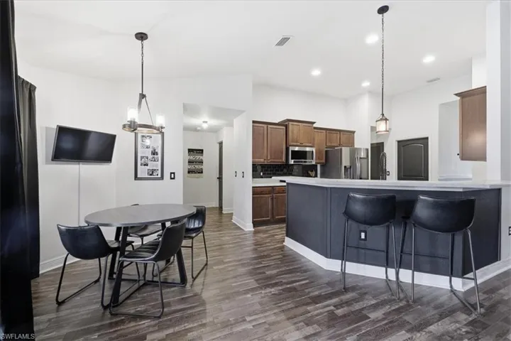 Open concept living area featuring wood-finish flooring, recessed lighting, and a modern kitchen