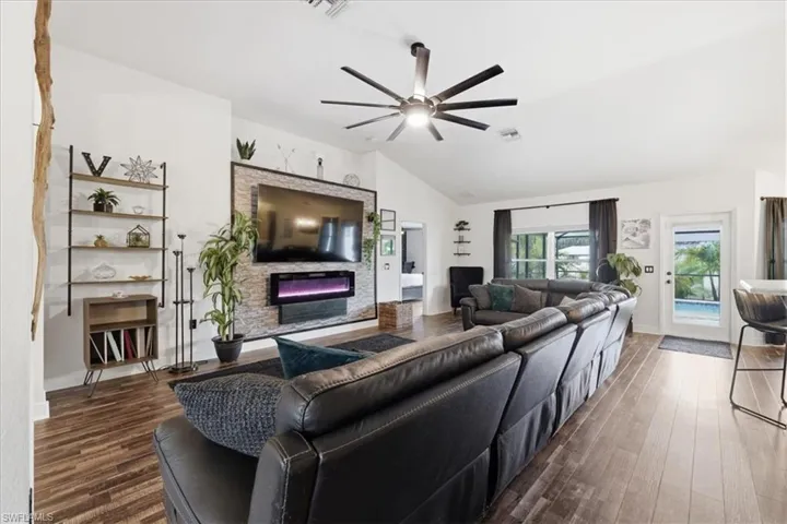 Spacious living area featuring vaulted ceilings and wood-finish flooring
