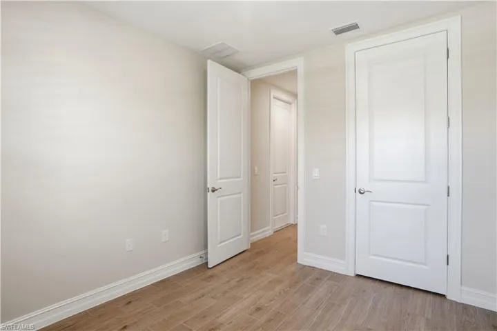 Unfurnished bedroom featuring light wood finished floors and baseboards