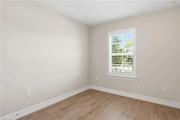 Spare room featuring light wood-style flooring and baseboards