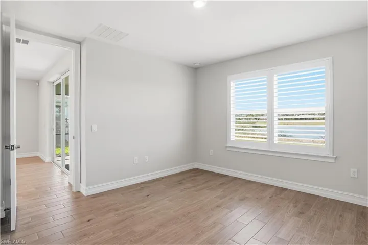 Spare room featuring light wood-style flooring and a water view
