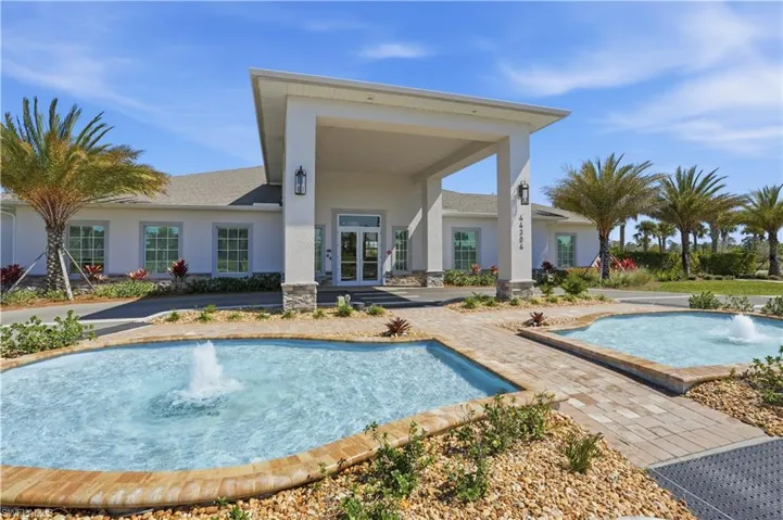 Rear view of house featuring stucco siding, french doors, a patio area, and stone siding