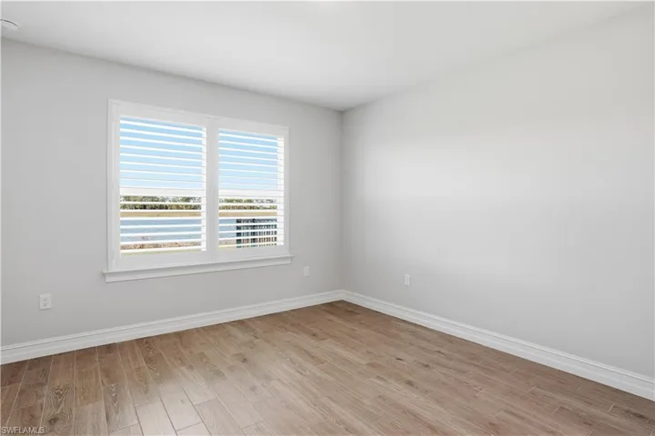 Empty room with light wood finished floors and a water view
