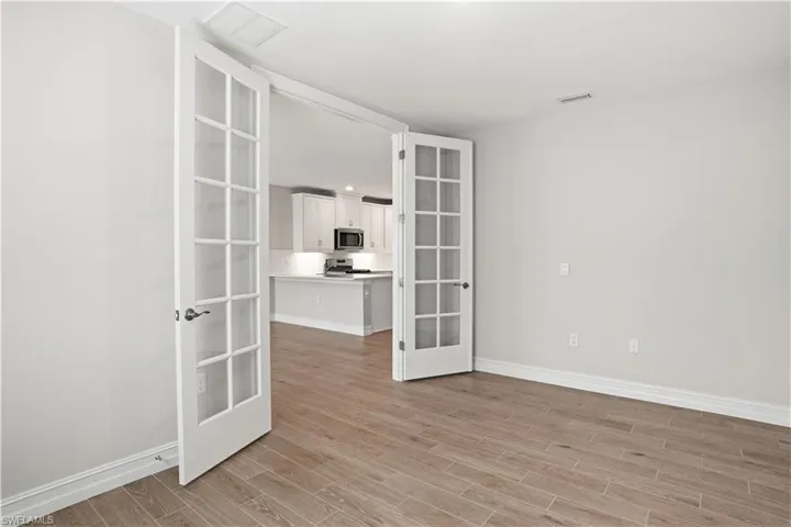 Empty room featuring french doors and wood finish floors