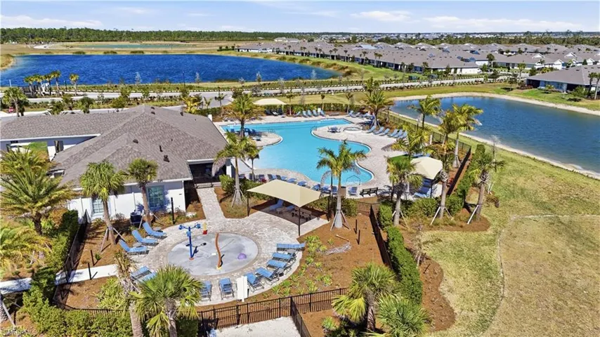 Aerial perspective of suburban area with a pool area and a nearby body of water