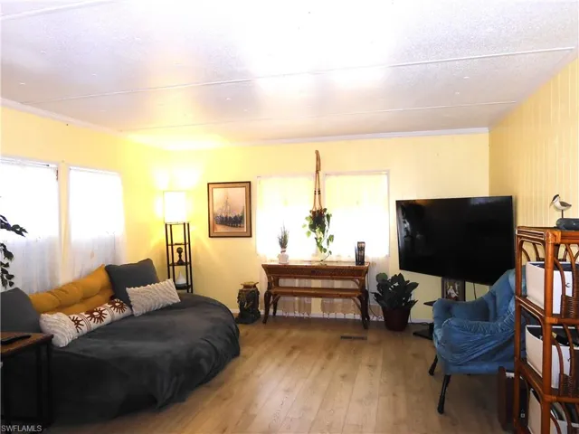 Living room with a textured ceiling and wood-type flooring