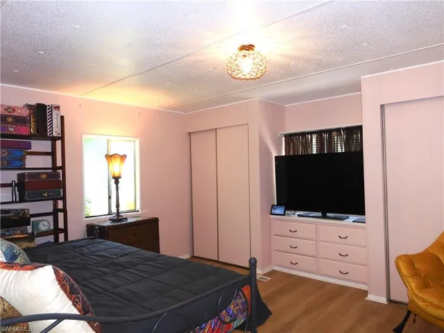 Bedroom featuring wood-type flooring, a closet, and a textured ceiling