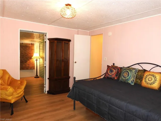 Bedroom with a textured ceiling, wood-type flooring, and billiards