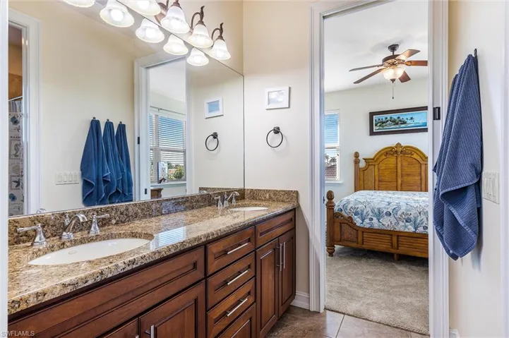 Bathroom featuring double vanity, tile patterned flooring, a sink, and a ceiling fan