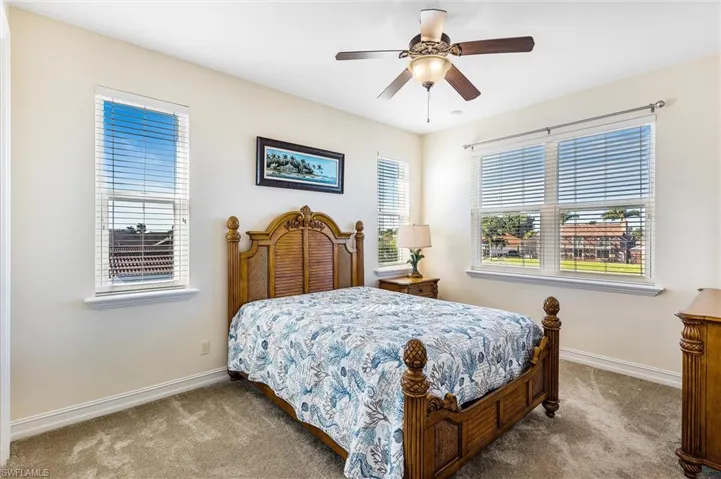 Bedroom with ceiling fan, carpet flooring, and baseboards