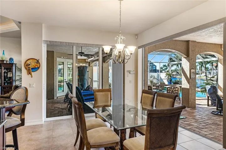 Dining room featuring light tile patterned floors, baseboards, and ceiling fan with notable chandelier