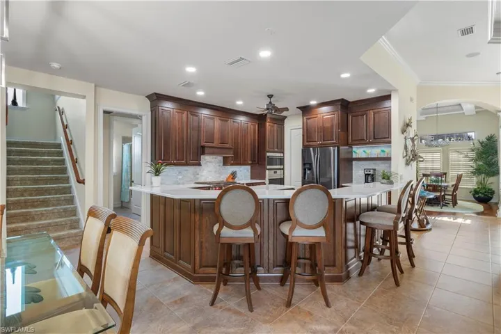 Kitchen with stainless steel appliances, light countertops, visible vents, backsplash, and a peninsula