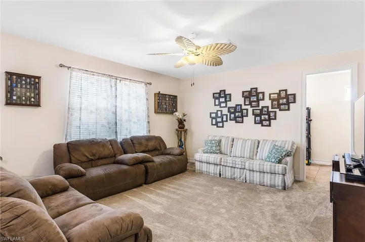 Living room with carpet flooring and ceiling fan