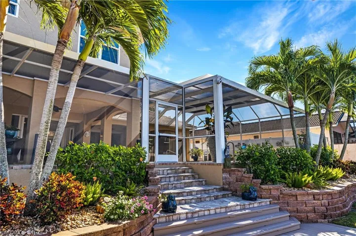 Rear view of house with a lanai and stucco siding