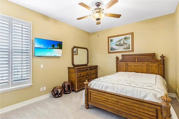 Bedroom with ceiling fan, carpet floors, visible vents, and baseboards