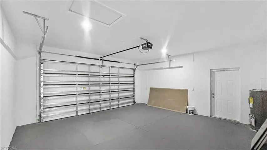 Garage featuring water heater and a garage door opener