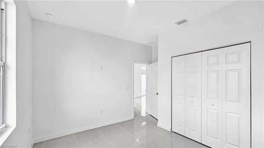 Unfurnished bedroom featuring light tile patterned floors and a closet