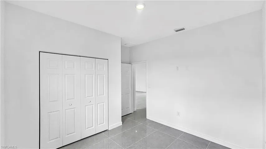 Unfurnished bedroom with tile patterned floors and a closet