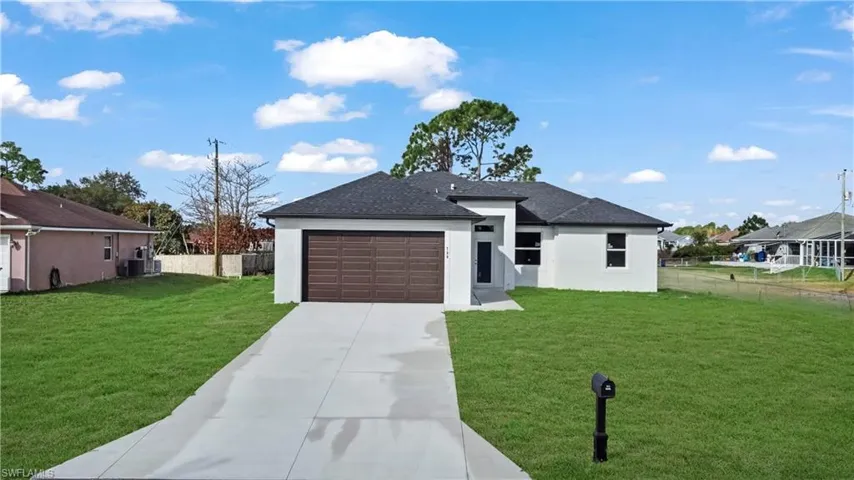 Prairie-style home with stucco siding, concrete driveway, an attached garage, and a shingled roof