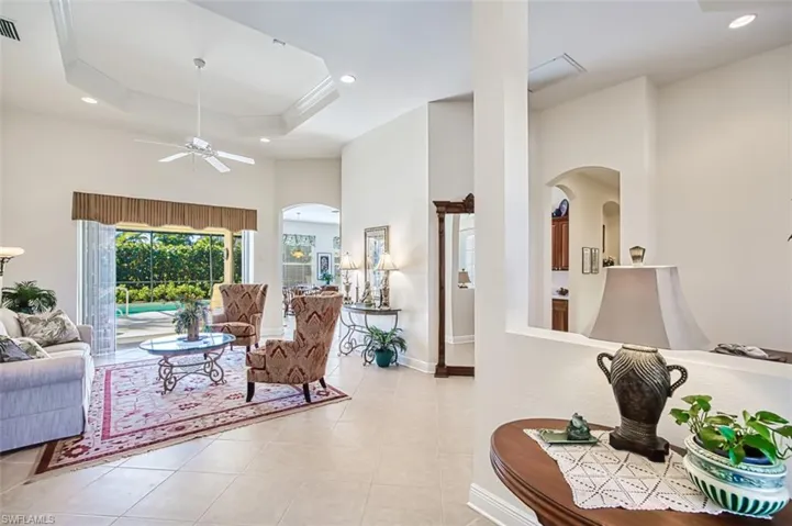 Living area with recessed lighting, a ceiling fan, light tile patterned floors, arched walkways, and crown molding