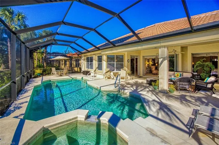 View of swimming pool featuring a pool with connected hot tub, a patio area, glass enclosure, a sunroom, and an outdoor hangout area