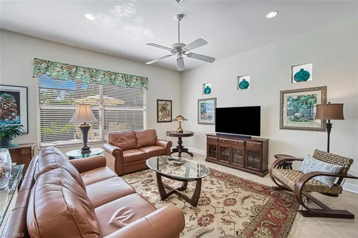 Living room featuring ceiling fan, light tile patterned flooring, and recessed lighting