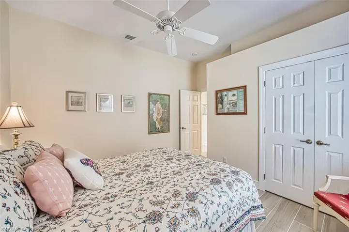 Bedroom featuring wood finish floors, a closet, and a ceiling fan