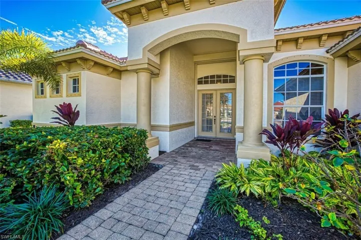 Property entrance featuring stucco siding, french doors, and a tiled roof