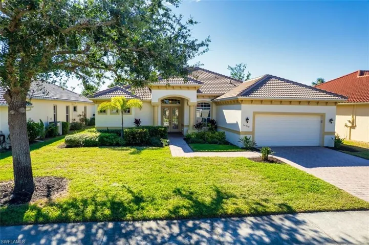 Mediterranean / spanish-style house featuring french doors, stucco siding, a front yard, and decorative driveway
