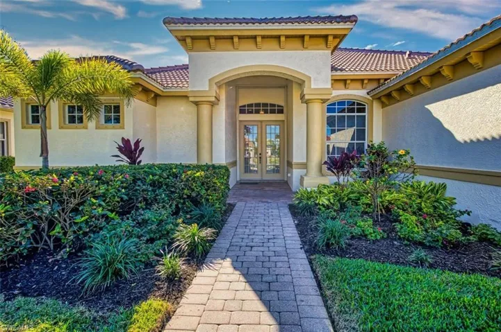 Entrance to property with stucco siding, a tile roof, and french doors