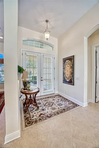 Entrance foyer with french doors, light tile patterned flooring, and arched walkways