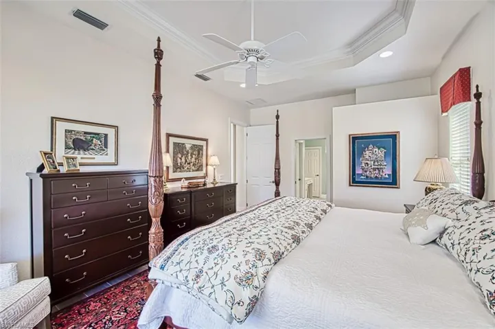 Bedroom featuring crown molding, a tray ceiling, a ceiling fan, and recessed lighting
