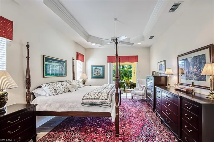 Bedroom with crown molding, ceiling fan, a tray ceiling, and access to exterior