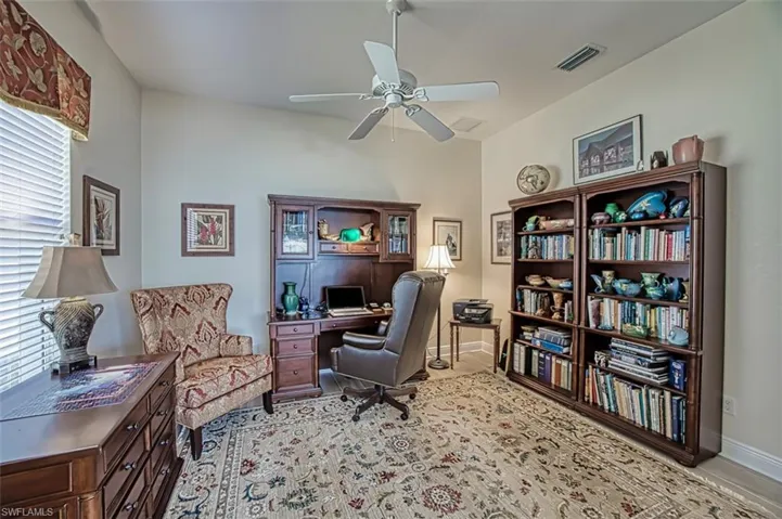 Office area with a ceiling fan and baseboards
