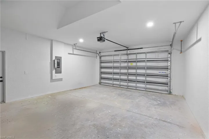 Garage with electric panel and a garage door opener