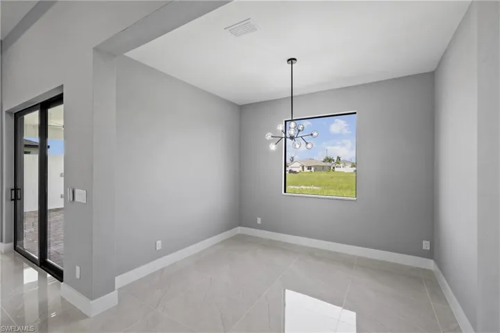 Spare room featuring light tile patterned floors and a chandelier