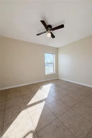 Unfurnished room with a ceiling fan and light tile patterned floors
