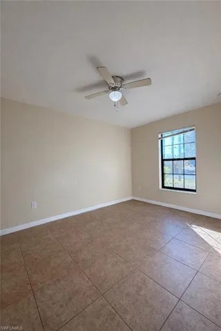 Spare room featuring light tile patterned flooring and a ceiling fan
