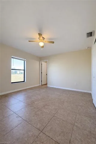 Spare room with ceiling fan and light tile patterned flooring