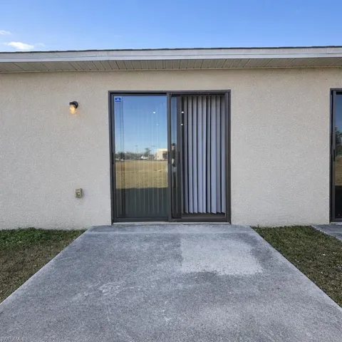 Doorway to property with stucco siding and a patio area