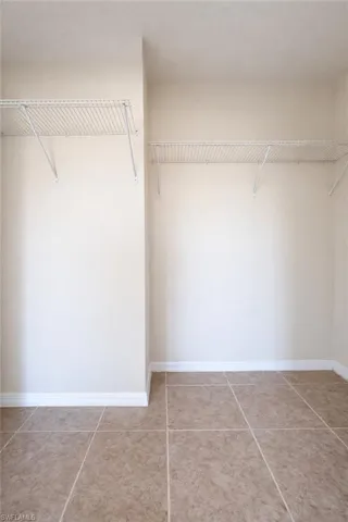 Spacious closet with light tile patterned floors