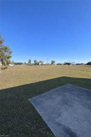 View of green lawn featuring a patio area