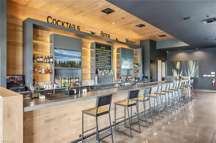 Bar featuring baseboards, wet bar, finished concrete flooring, visible vents, and wood ceiling