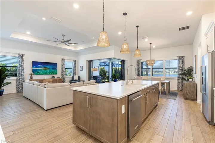 Kitchen with light wood-type flooring, appliances with stainless steel finishes, a sink, and visible vents