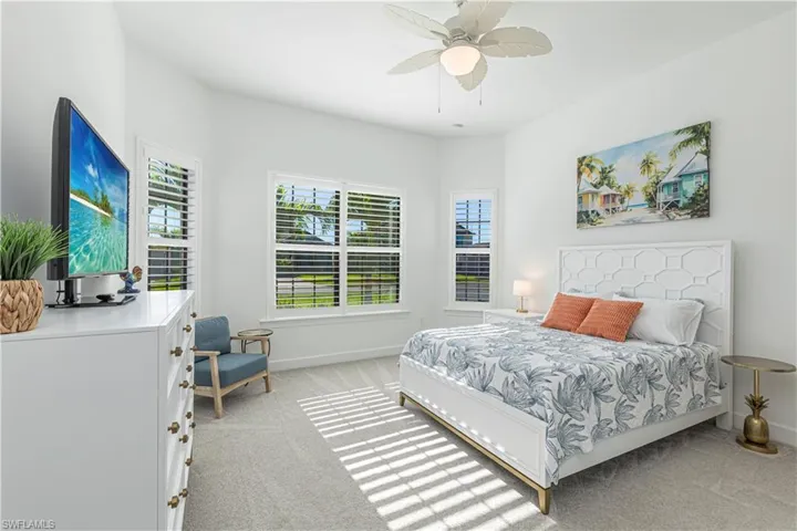 Bedroom with baseboards, ceiling fan, and light carpet